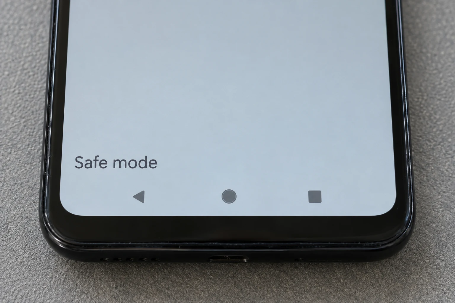 Close-up of the lower part of a phone screen displaying Safe mode above the navigation buttons.